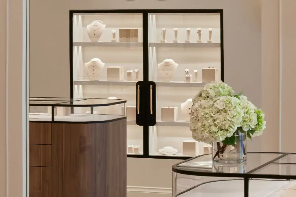 Close-up of a modern jewellery showcase highlighting diamond and gold necklaces, rings, and earrings in a luxury boutique setting.