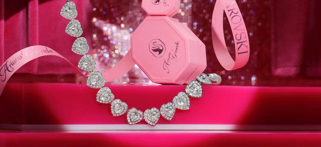 Stunning diamond heart necklace on pink display, perfect for gift-giving and special occasions.